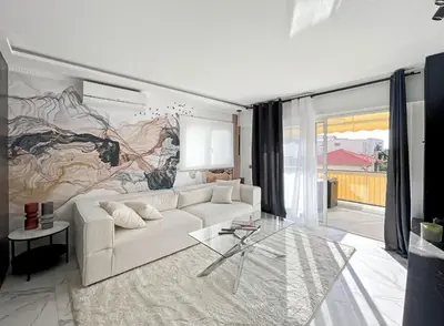 a living room with a white couch and a large mural at Appartement Moderne à Cannes in Cannes