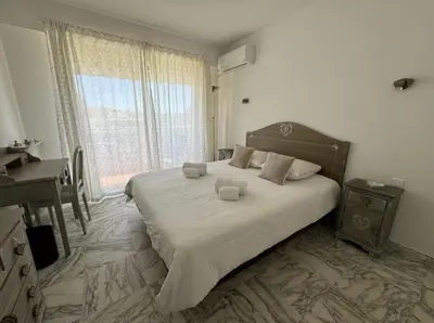 a bedroom with a bed with a desk and a window at Cozy one bedroom apartment with balcony and parking in Cannes