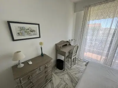 a bedroom with a dresser and a desk next to a window at Cozy one bedroom apartment with balcony and parking in Cannes