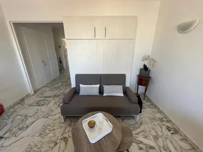 a living room with a couch and a table at Cozy one bedroom apartment with balcony and parking in Cannes