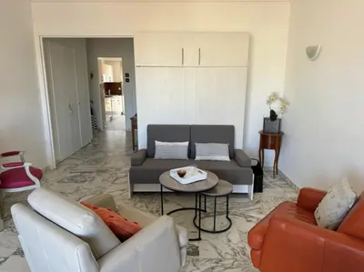 a living room with a couch and a table at Cozy one bedroom apartment with balcony and parking in Cannes