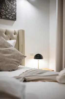 a bedroom with a bed and a black lamp at Jessicannes Hoche 4 min Palais Festival & Beaches in Cannes