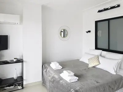 a white bedroom with a bed with towels on it at Studio apartment on La Croisette with terrace in Cannes