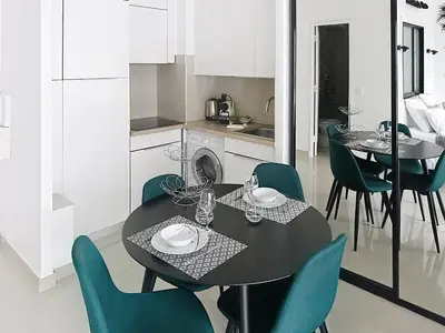 a kitchen and dining room with a black table and chairs at Studio apartment on La Croisette with terrace in Cannes
