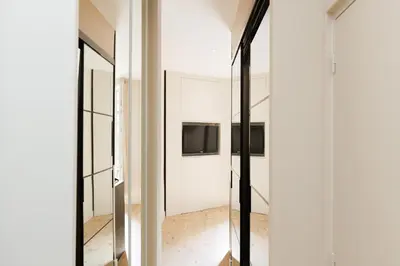 a room with mirrors and a tv on the wall at Palais Miramar YourHostHelper in Cannes