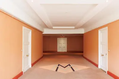 an empty room with orange walls and a white ceiling at Palais Miramar YourHostHelper in Cannes