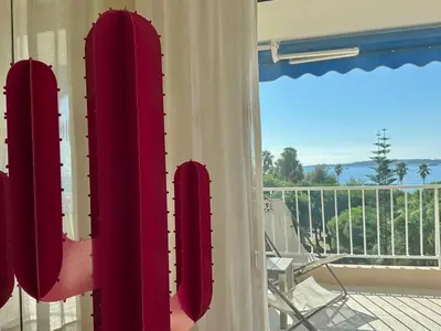 a room with a balcony with a view of the ocean at Reflets d'Azur - Vue mer, plage, neuf, moderne in Cannes