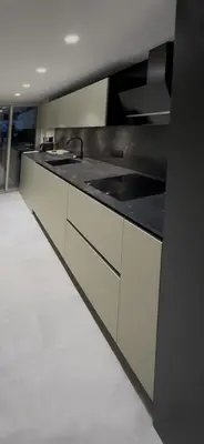 a kitchen with white cabinets and a black counter top at Reflets d'Azur - Vue mer, plage, neuf, moderne in Cannes