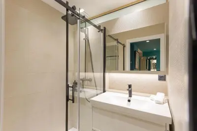 a bathroom with a sink and a mirror at Reflets d'Azur - Vue mer, plage, neuf, moderne in Cannes