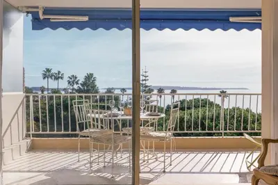 a balcony with a table and a view of the ocean at Reflets d'Azur - Vue mer, plage, neuf, moderne in Cannes