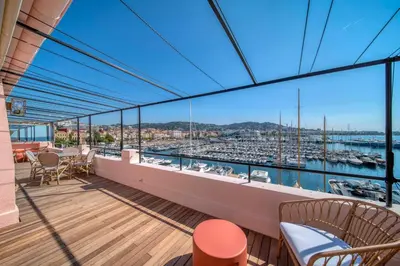 a balcony with chairs and a view of a marina at REF 1923 - Cannes Vieux-Port 5-star penthouse for rent sea view in Cannes