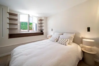 a white bedroom with a large white bed with two pillows at REF 1923 - Cannes Vieux-Port 5-star penthouse for rent sea view in Cannes