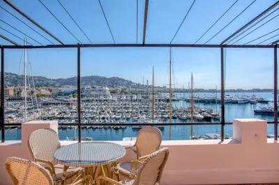 a balcony with a table and chairs and a harbor at REF 1923 - Cannes Vieux-Port 5-star penthouse for rent sea view in Cannes