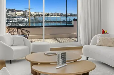 a living room with a view of a harbor at REF 1923 - Cannes Vieux-Port 5-star penthouse for rent sea view in Cannes