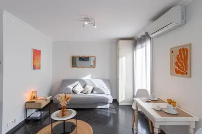 a living room with a couch and a table at Rue Hoche by Halldis in Cannes