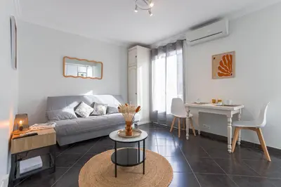 a living room with a couch and a table at Rue Hoche by Halldis in Cannes