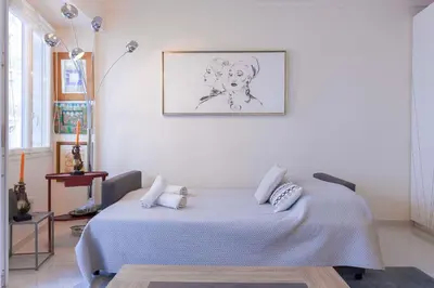 a white room with a bed with a picture on the wall at Palais Des Iles 2 by Halldis in Cannes