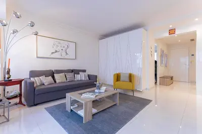 a living room with a couch and a table at Palais Des Iles 2 by Halldis in Cannes