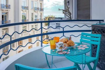 a table with a plate of food on a balcony at Palais Des Iles 2 by Halldis in Cannes