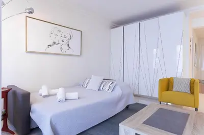 a bedroom with a bed and a yellow chair at Palais Des Iles 2 by Halldis in Cannes
