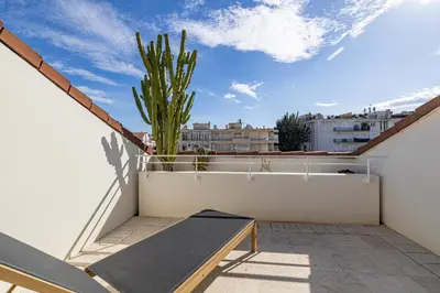a balcony with a bench and a cactus on a roof at REF 823 - Cannes Center - Duplex apartment for rent in Cannes