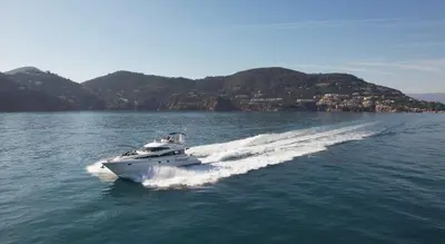 a boat on the water with mountains in the background at Superbe yacht dans le port de Cannes in Cannes