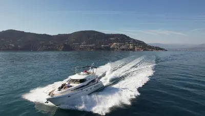 a white boat in the water with a trail at Superbe yacht dans le port de Cannes in Cannes