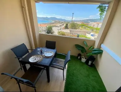 a table and chairs in a room with a large window at T2 Vue Mer à Cannes in Cannes