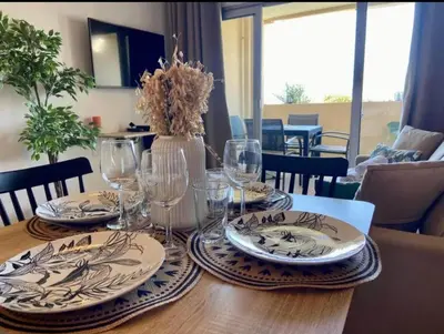 a wooden table with plates and glasses on it at T2 Vue Mer à Cannes in Cannes