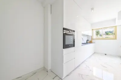 a white kitchen with white cabinets and a window at Spacious 2-Br Apartment in a Residence with Pool in Cannes