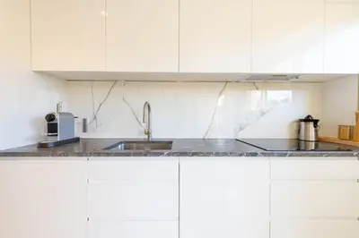 a kitchen with white cabinets and a sink at Spacious 2-Br Apartment in a Residence with Pool in Cannes