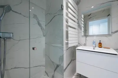 a bathroom with a shower and a sink and a mirror at Spacious 2-Br Apartment in a Residence with Pool in Cannes