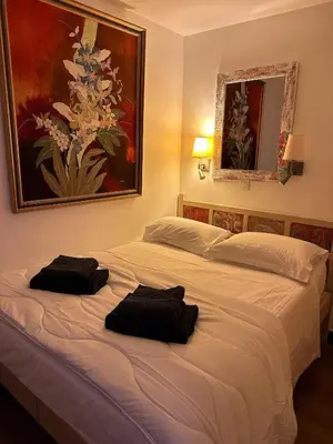 a large white bed with two black towels on it at Sisley 068 - F2 et magnifique vue mer in Cannes