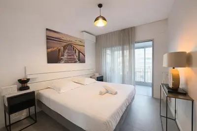 a white bedroom with a bed and a view of a bridge at BEAUTIFUL 1 - BR APARTMENT - Next To Rue Antibes in Cannes