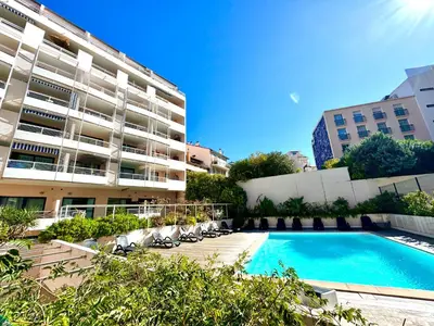 a swimming pool in front of a large building at Joséphines in Cannes