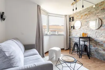 a living room with a couch and a brick wall at Joséphines in Cannes