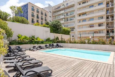 a swimming pool with lounge chairs next to a building at Joséphines in Cannes