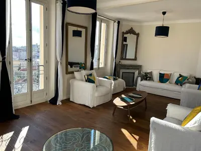 a living room with white furniture and a large window at Spacieux proche Palais Festival in Cannes