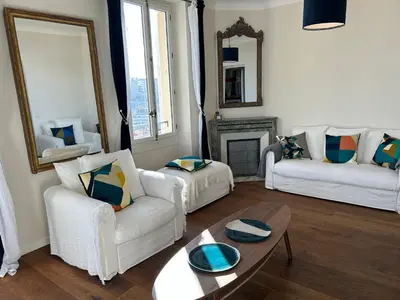 a living room with two white couches and a table at Spacieux proche Palais Festival in Cannes
