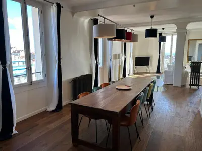 a dining room with a wooden table and chairs at Spacieux proche Palais Festival in Cannes