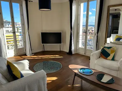 a living room with a couch and a tv at Spacieux proche Palais Festival in Cannes