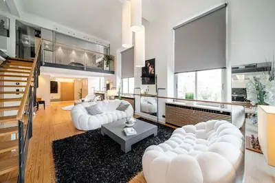a living room with white furniture and a staircase at REF 1985 - Cannes - Duplex for rent in Cannes
