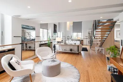 a living room with white chairs and a staircase at REF 1985 - Cannes - Duplex for rent in Cannes