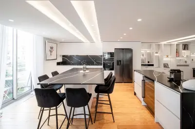 a kitchen with a black counter and black chairs at REF 1985 - Cannes - Duplex for rent in Cannes
