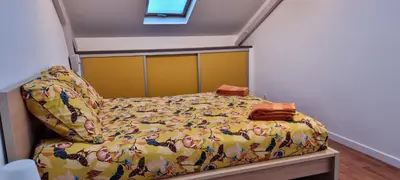 a bed in a room with a yellow comforter at Villa Magenta in Cannes