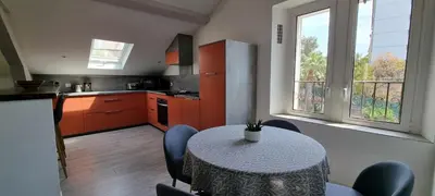 a kitchen with a table and chairs and a kitchen with orange cabinets at Villa Magenta in Cannes