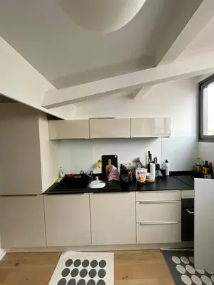 a kitchen with white cabinets and a black counter top at Beautiful modern apartment in Cannes in Cannes