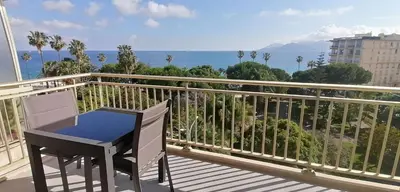 a balcony with a table and a view of the ocean at Cannes centre-ville - Face mer 3 pièces avec terrasse in Cannes