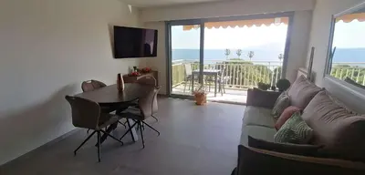 a living room with a couch and a table at Cannes centre-ville - Face mer 3 pièces avec terrasse in Cannes