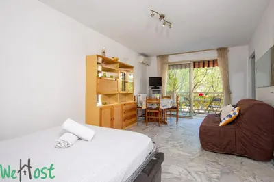 a bedroom with a bed and a dining room at Studio - Palais des Festivals in Cannes